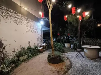 a courtyard with a tree and a wall with lights at Homestay Lung Tok in Bukit Mertajam