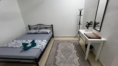 a bedroom with a bed and a table and a desk at D'Simpang Homestay in Sungai Petani