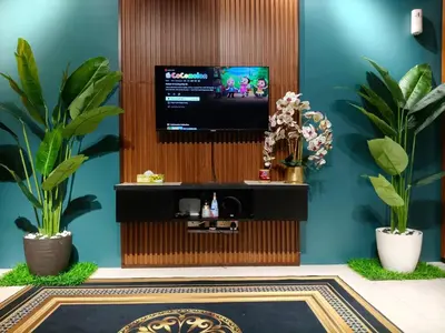 a living room with a tv on a wall with plants at Adila Alfina Heaven Homestay Cameron Highlands in Tanah Rata