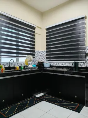 a kitchen with black counters and two windows at Adila Alfina Heaven Homestay Cameron Highlands in Tanah Rata