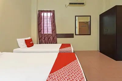 a hotel room with two beds and a window at SPOT ON 91178 Motel Impian in Kampong Telok Batu