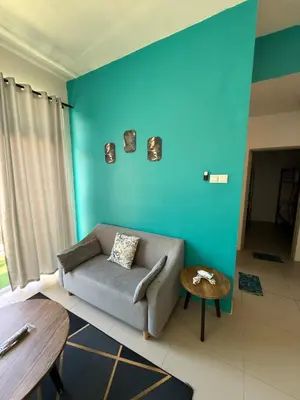 a living room with a couch and a blue wall at AYAAN Tulip Golden Hills Home Near Night Market Free Parking in Brinchang