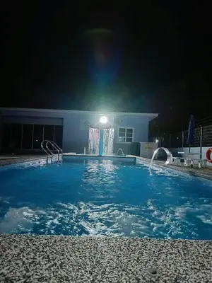 a swimming pool at night with a fountain at Villa Atok Opah in Teluk Intan