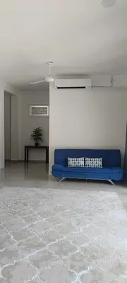 a living room with a blue couch in a room at Villa Atok Opah in Teluk Intan