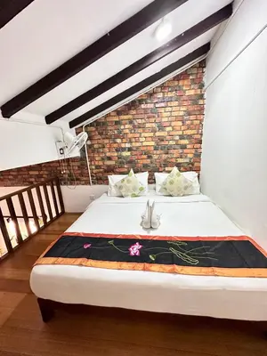 a bed in a room with a brick wall at Rangoon Residence 26 in George Town