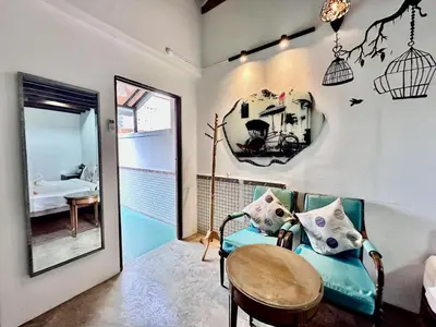 a room with a chair and a table and a mirror at Rangoon Residence 26 in George Town