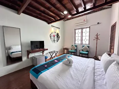 a bedroom with a large bed and a mirror at Rangoon Residence 26 in George Town