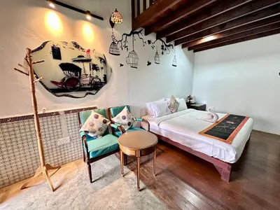 a bedroom with a bed and a table and a chair at Rangoon Residence 26 in George Town
