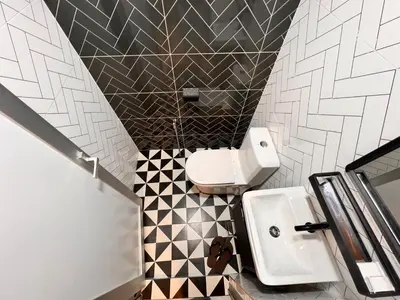 a bathroom with a white toilet and a sink at Glitz Hotel in Brinchang