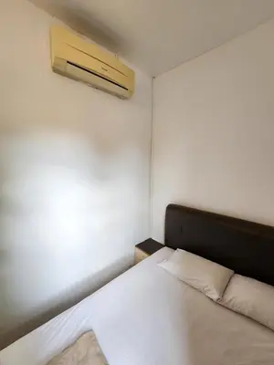 a small room with a bed and a air conditioner at Rasa Motel at Batu Ferringhi in Batu Ferringhi