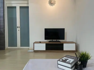 a living room with a flat screen tv on a table at Woodsbury Suites Butterworth in Butterworth