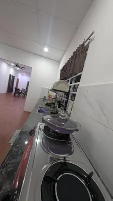 a kitchen with a stove with pots and pans on it at Abadi's Homestay in Tanjung Karang
