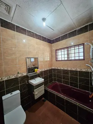 a bathroom with a red tub and a toilet and a sink at Teratak Abah in Seri Manjung