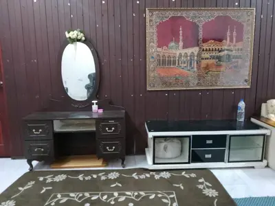 a bathroom with a sink and a mirror and a cat in a drawer at Homestay Melati in Ipoh