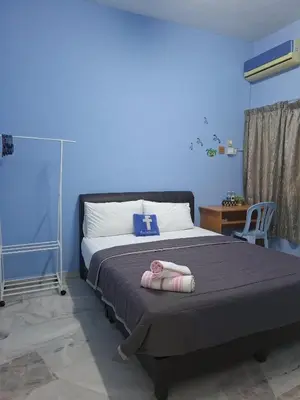 a bedroom with a large bed with a blue wall at ACACIA GUESTHOUSE by Zamanja in Ipoh