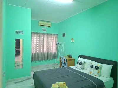 a bedroom with blue walls and a bed with pillows at ACACIA GUESTHOUSE by Zamanja in Ipoh