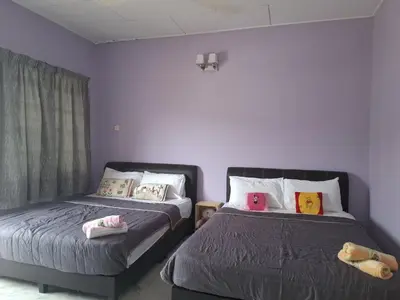 two beds in a room with purple walls at ACACIA GUESTHOUSE by Zamanja in Ipoh