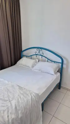 a blue bed with two white pillows on it at Hide-out in Tanjong Tokong