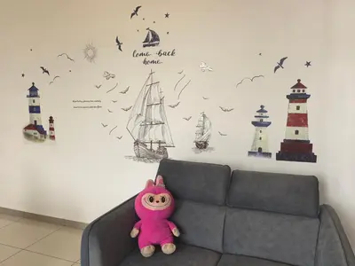 a teddy bear sitting on a couch in a room with a wall at Padang Serai Wangi Homestay 95 in Padang Serai