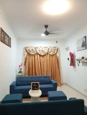 a living room with a blue couch and a table at Auliya homestay in Gua Sai
