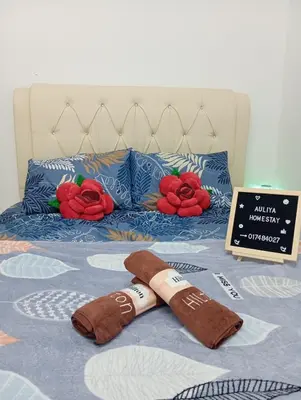 a pair of slippers are laying on a bed at Auliya homestay in Gua Sai