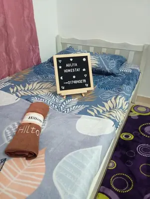 a sign sitting on top of a bed at Auliya homestay in Gua Sai