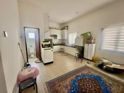 a room with a kitchen with a rug on the floor at homestay juliana rinching tengah in Gua Sai