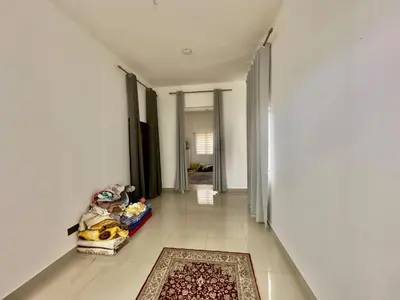 a hallway with white walls and a rug on the floor at homestay juliana rinching tengah in Gua Sai