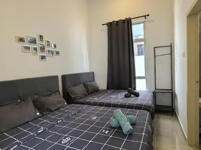 a bedroom with a bed with a teddy bear on it at Padang Serai Wangi Homestay 91 in Padang Serai