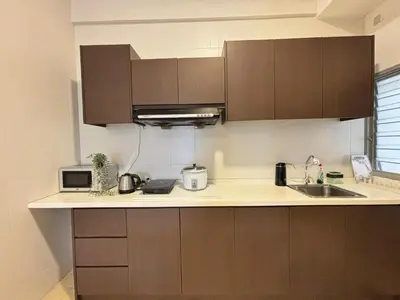 a kitchen with brown cabinets and a sink and a microwave at JS Comfortable Stay Golden Hills Pasar Malam 3Bedrooms 2Bathrooms in Brinchang