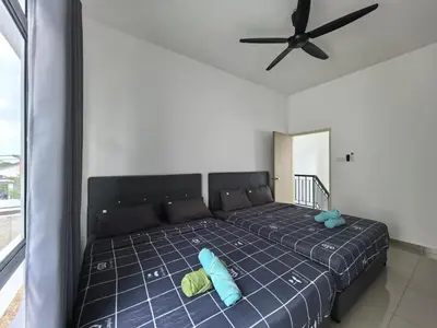 a bedroom with a bed with two pillows and a ceiling fan at Padang Serai Wangi Roomstay 95 in Padang Serai
