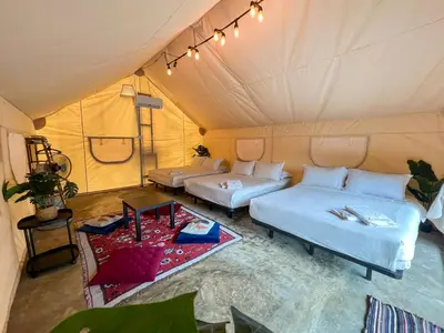 a room with two beds and a table in a tent at Glamping at Xscape Tambun in Ipoh