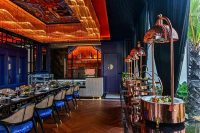 a restaurant with long tables and blue chairs at Bertam Wellness Spa & Villas - A Member of Small Luxury Hotels of the World in Kepala Batas