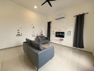 a living room with a couch and a tv at Family Room with Private Bathroom in Padang Serai