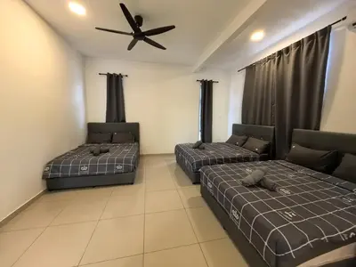 two beds in a room with a ceiling fan at Family Room with Private Bathroom in Padang Serai