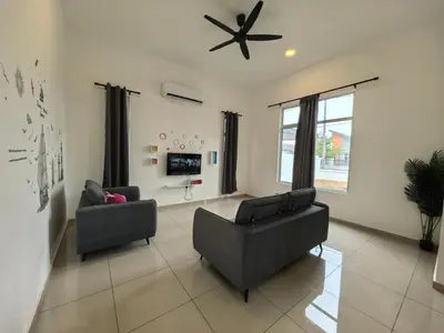 a living room with two chairs and a ceiling fan at Family Room with Private Bathroom in Padang Serai