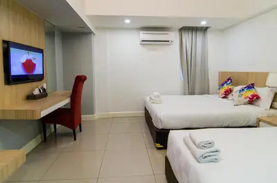 a hotel room with two beds and a desk at Mornington Hotel Waterfront Lumut in Lumut