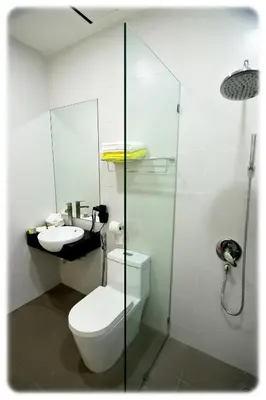 a white bathroom with a toilet and a sink at Mornington Hotel Waterfront Lumut in Lumut