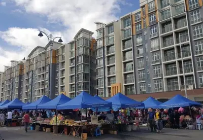 a market in front of a large building with blue umbrellas at Kareena Barrington Square Goldenhills Pasar Malam Cameron Highlands in Brinchang