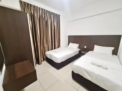a hotel room with two beds and a window at Marina Teluk Batik by Manhattan Group in Lumut