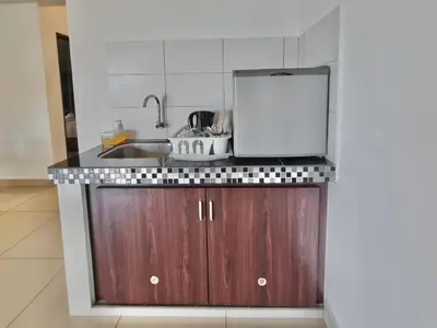 a kitchen with a sink and a counter top at Marina Teluk Batik by Manhattan Group in Lumut