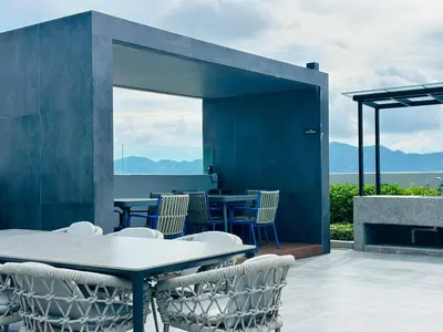 a patio with a table and chairs with a view at Sky Pool Luxury Stay Sea View Bayan Airport in Bayan Lepas