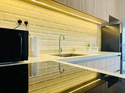 a kitchen with a sink and a microwave at CozyStay Rooftop Sky Pool Sea &Bridge View Luxury 9pax in Bayan Lepas