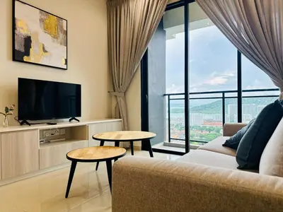 a living room with a couch and a tv at Luxe Seaview Rooftop Pool Airport bayan lepas in Bayan Lepas