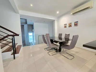 a dining room with a black table and chairs at Shamrock Beach Villas - Batu Ferringhi in Tanjung Bungah