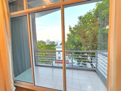 a balcony with sliding glass doors with a view at Shamrock Beach Villas - Batu Ferringhi in Tanjung Bungah