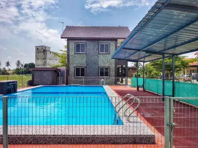 a swimming pool in front of a house at Inapan Tepi Sawah