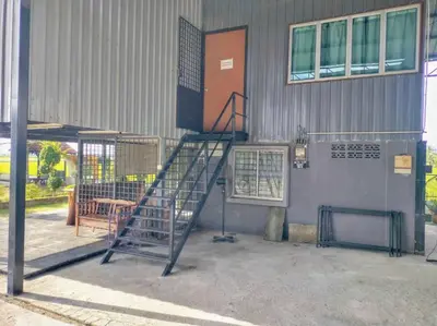 a metal staircase in front of a building at Inapan Tepi Sawah