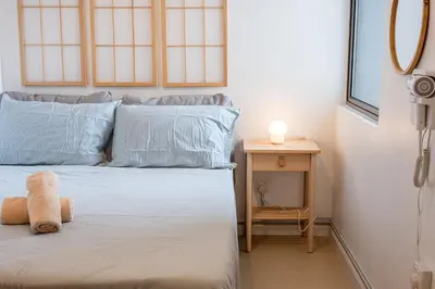 a bedroom with a bed with a teddy bear on it at Serene Japandi Family Retreat 2-6 pax& Sunrise View in Brinchang