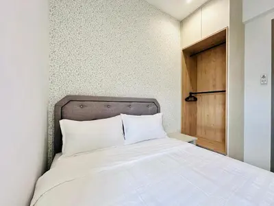 a bedroom with a white bed with a wooden door at High Rise Haven 3BR Rooftop Pool Stylish Comfort 9pax in Bayan Lepas